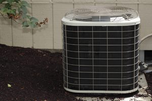 Free standing air conditioner in the exterior back of a home used to cool the house interior in the summer heat.